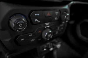 Detailed view of car dashboard featuring volume, AC, and power controls in a luxury vehicle.