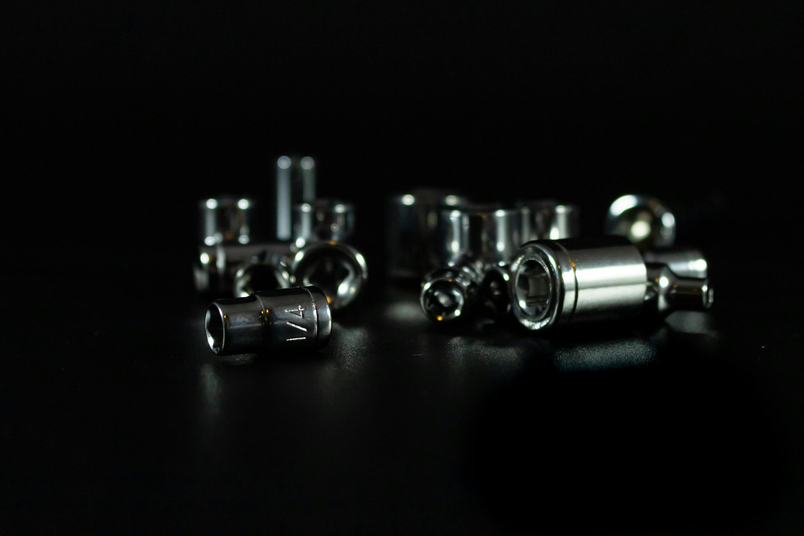 Close-up of a stainless steel socket set with a blurred background.