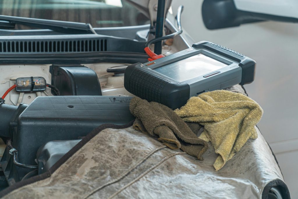 pexels photo 4116191 4116191 Close-up of car diagnostics tool on engine in a garage setting.